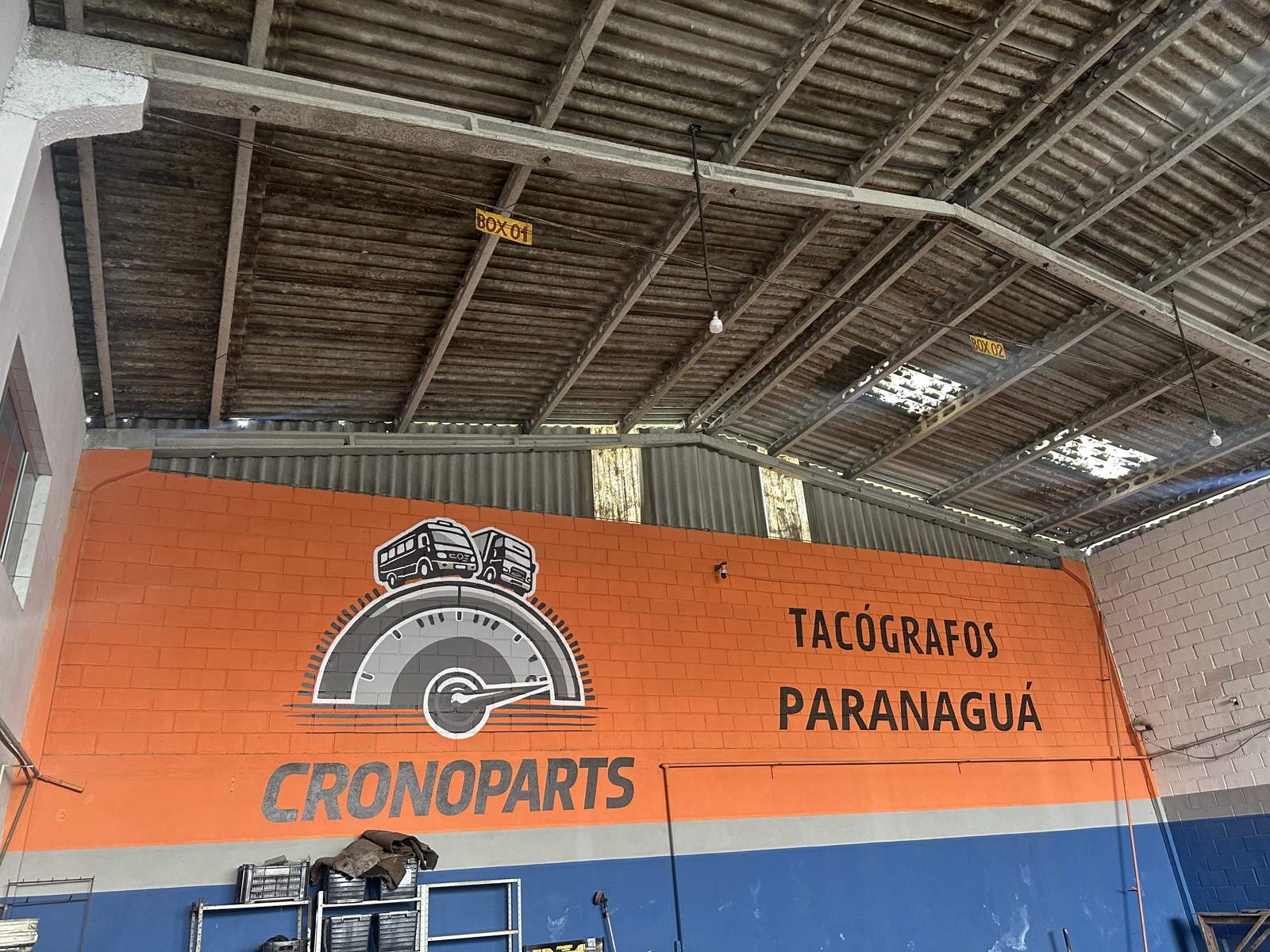 Parede laranja com o logo da CronoParts